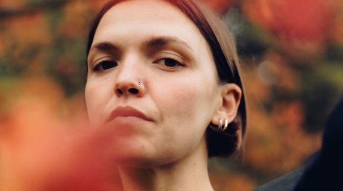 A woman with short brown hair and two silver hoop earrings in her ear